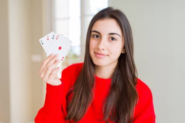 Poker oynayan genç ve güzel bir kadın. Kendine güvenen bir yüz ifadesiyle. Ciddi düşünüyor.
