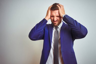 Beyaz tenli genç iş adamı acı ve migren yüzünden çaresiz ve stresli bir baş ağrısından muzdarip. Ellerini başının üstüne koy..