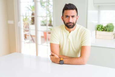 Yakışıklı, İspanyol asıllı, sıradan, kuşkucu ve gergin, yüzünde çapraz kollu, onaylamayan bir ifade var. Negatif kişi.