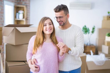 Genç neşeli çift mutlu gösteren düğün yüzük, yeni bir eve hareket nişan kutluyor gülümseyen