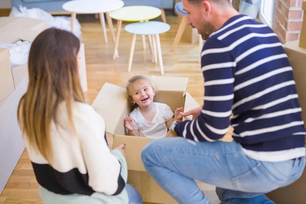 Güzel famiily, yeni evde karton fanny kutusu sürme ailesi ile oynayan çocuk
