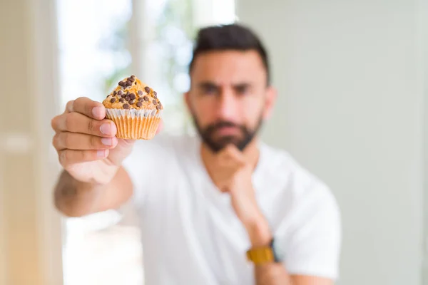 Bel Homme Hispanique Manger Des Pépites Chocolat Muffin Visage Sérieux — Photo