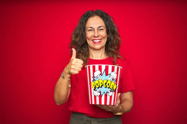 Donna Anziana Mezza Età Mangiare Spuntino Popcorn Sfondo Rosso Isolato — Foto Stock