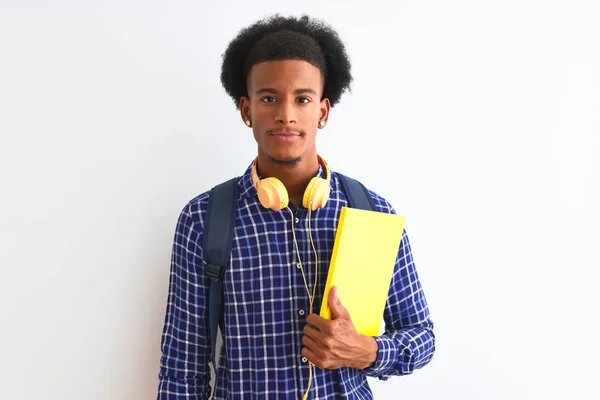 African american student man wearing headphones backpack over isolated white background with a confident expression on smart face thinking serious