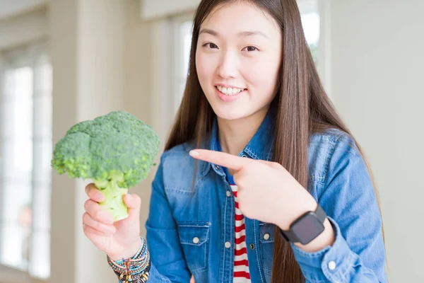 Vacker Asiatisk Kvinna Äter Grön Färsk Broccoli Mycket Glad Pekar — Stockfoto