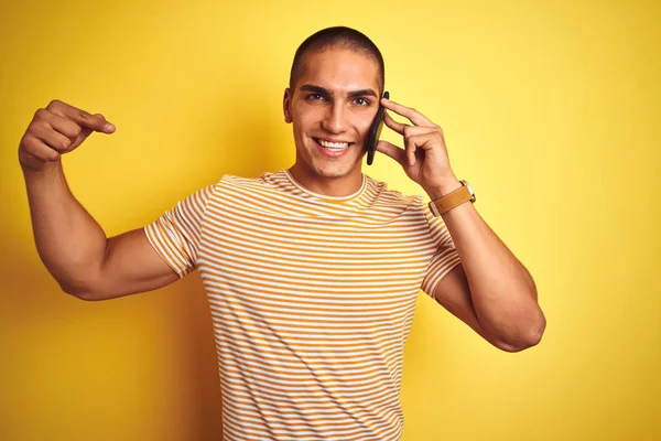 Młody Przystojny Mężczyzna Mówi Pomocą Smartfona Żółtym Odizolowanym Tle Niespodzianka — Zdjęcie stockowe