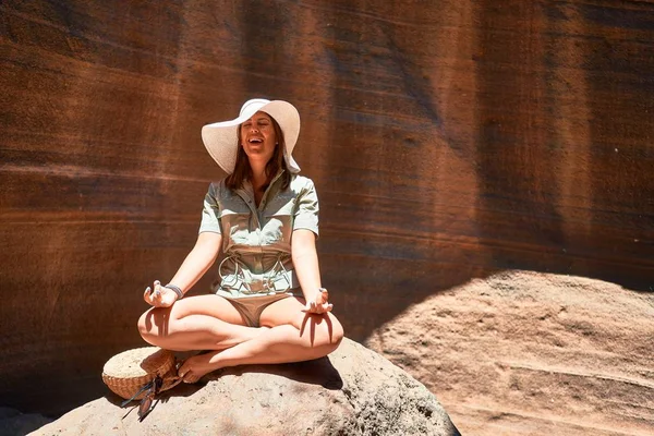 Young beauitufl hiker woman trekking natural orange mountain doing yoga pose on summer holidays