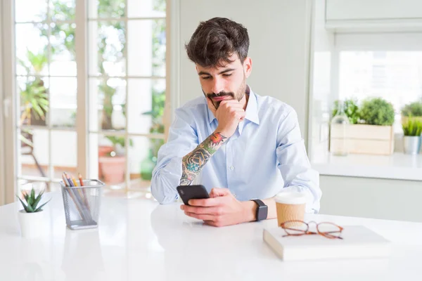 Young Business Man Using Smartphone Sending Message Serious Face Thinking — Stock Photo, Image