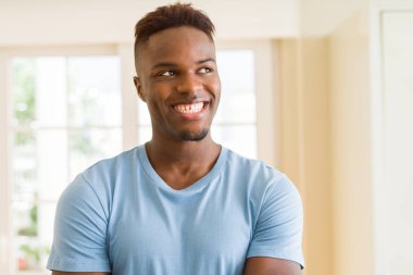 Çapraz kolları ile neşeli gülümseyen Afrika yakışıklı genç