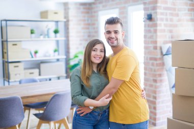 Yeni eve hareketli karton kutular etrafında aşık genç güzel çift, yeni daire için çok mutlu ve neşeli gülümseyen