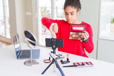 Genç Afrikalı Amerikalı Etkilenen Kadın Makyaj dersini kızgın yüzle kaydediyor. Eksi işareti baş parmakları aşağıda, reddedilme konsepti reddedildi.