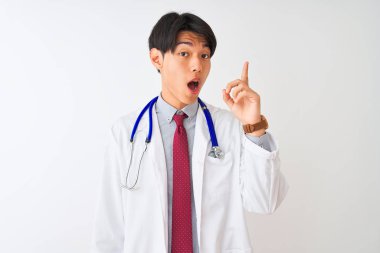 Ceket kravatı takan Çinli doktor ve steteskop izole edilmiş beyaz arka plan üzerinde başarılı bir fikirle parmağı işaret ediyor. Heyecanlı ve mutlu. Bir numara..
