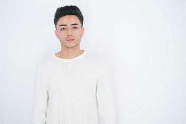 Yüzünde ciddi bir ifade olan beyaz tenli yakışıklı bir genç. Basit ve doğal bir şekilde kameraya bakıyorsun..