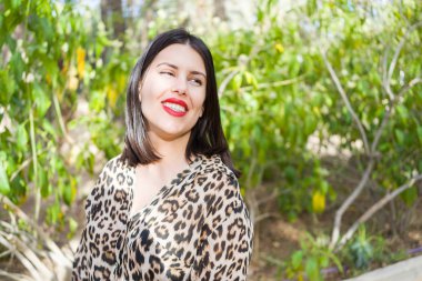 Bahçede mutlu gülümseyen kırmızı dudaklı genç güzel kadın