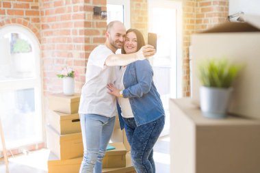 Yeni evde Smartphone kullanarak bir resim fotoğraf çekerken genç çift