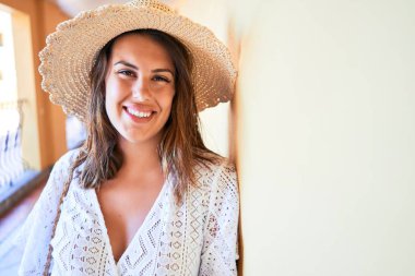 Genç ve güzel bir kadın yaz tatilinde mutlu ve mutlu bir şekilde otelde gülümsüyor.