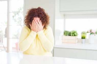 Sarı kazak giyen, suratını elleriyle kapatan ve ağlayan güzel bir son sınıf öğrencisi. Depresyon kavramı.