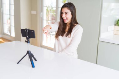 Akıllı telefon kamerası ile güzel genç kadın kayıt selfie video çok mutlu el ve parmak ile işaret