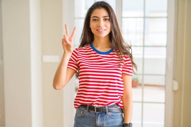 Gösterilen ve parmakları ile işaret rahat t-shirt giyen genç güzel kadın ikincisi ise kendinden emin ve mutlu gülümseyerek.