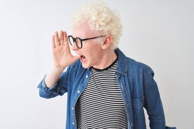 Kot gömlek ve gözlük takan genç albino sarışın adam izole edilmiş beyaz arka planda avazı çıktığı kadar bağırıyor ve ağızdan ağıza bağırıyordu. İletişim konsepti.