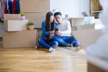 Genç Asya çift oturma üzerinde the zemin arasında yeni daire civarı