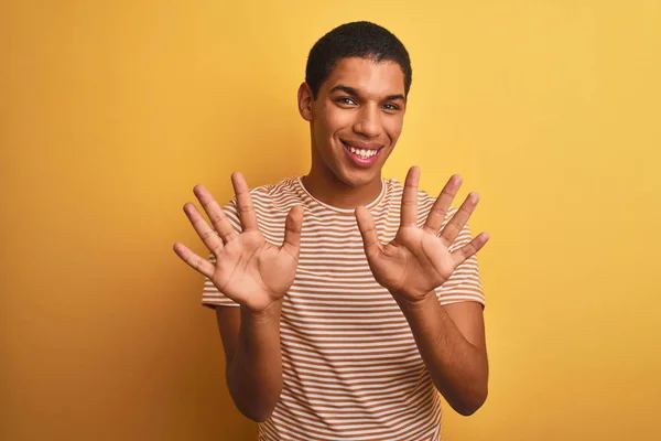 年轻英俊的阿拉伯男子穿着条纹T恤 站在孤立的黄色背景上 露出十号手指 面带微笑 自信而快乐 — 图库照片
