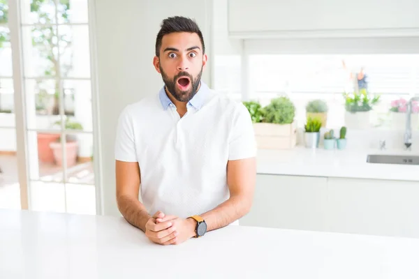 英俊的西班牙男子休闲白色T恤在家里害怕和震惊与惊喜的表情 恐惧和兴奋的脸 — 图库照片