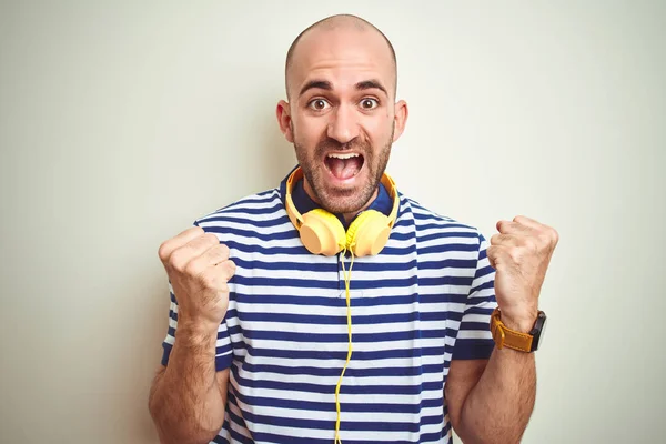 Joven Escuchando Música Con Auriculares Amarillos Sobre Fondo Aislado Celebrando —  Fotos de Stock