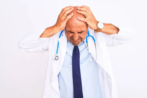 中年の医師の男性は 聴診器を着用し 痛みや片頭痛のために必死の頭痛やストレスに苦しんで隔離された白い背景の上に立ってネクタイ 手を頭に — ストック写真