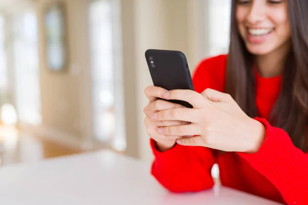 Jovem mulher usando smartphone, sorrindo mensagens de texto felizes e digitação — Fotografia de Stock