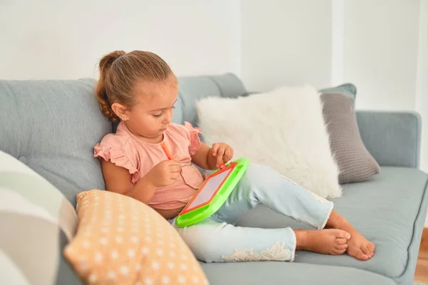 Schöne Blonde Kleinkind Mädchen Sitzt Auf Dem Sofa Zeichnung Mit — Stockfoto