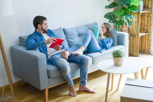 Pareja Joven Relajándose Sofá Leyendo Libro Tomando Descanso Para Mudarse — Foto de Stock