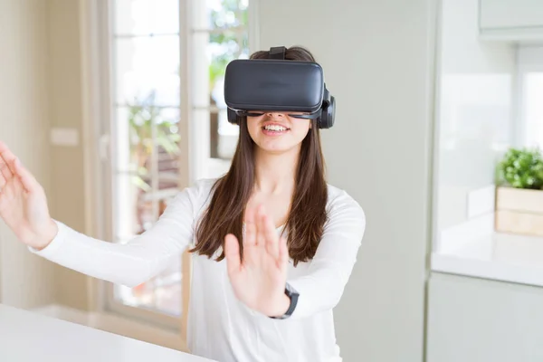Mujer joven jugando juego de realidad virtual utilizando la simulación de cristal —  Fotos de Stock