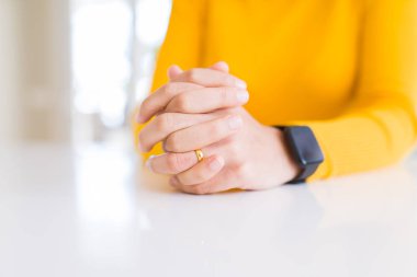 Beyaz masa üzerinde düğün Birliği giyen genç kadın elleri yakın