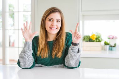Güzel, iri yarı, sıradan çizgili süveter giyen genç bir kadın yedi numaralı parmaklarıyla onu gösterirken kendine güvenen ve mutlu bir şekilde gülümsüyor..