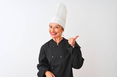Üniformalı ve şapkalı orta yaşlı bir aşçı kadın izole edilmiş beyaz arka planda mutlu bir el hareketi yapıyor. Kameraya bakıp başarıyı gösteren ifade onaylanıyor.