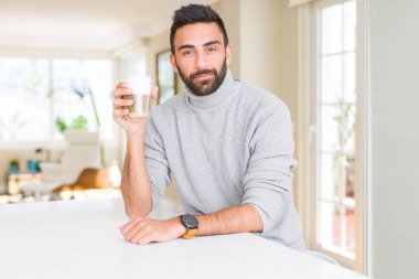 Yakışıklı İspanyol adam ciddi düşünme akıllı yüz kendine güvenen bir ifade ile bir fincan kahve içme