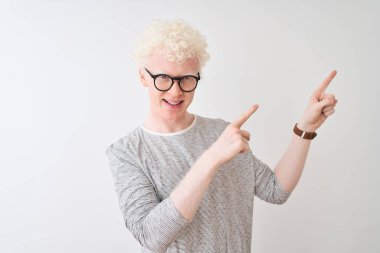İzole edilmiş beyaz arka plan üzerinde çizgili tişört ve gözlüklü genç albino adam gülümsüyor ve kameraya bakıyor..