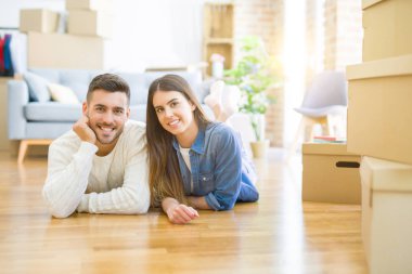 Yeni evin katında yatan genç güzel çift, yeni daireye taşınmak için çok mutlu aşk gülümsüyor