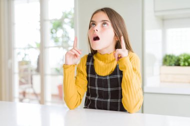 Genç, güzel, sarışın, günlük sarı süveter giyen kız şaşırmış ve şaşırmıştı. Parmaklarıyla işaret ediyor ve kollarını kaldırıyordu..