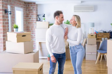 Karton kutuların etrafında duran genç ve güzel bir çift.