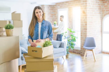 Genç çift yeni bir ev, güzel kadın hareketli karton kutu gülümseyen hareket