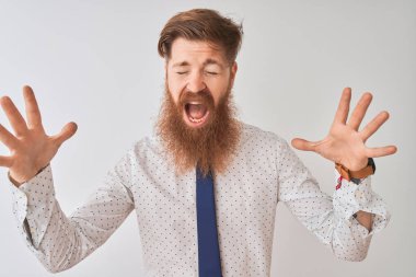 Genç kızıl saçlı İrlandalı işadamı, izole edilmiş beyaz arka planda kollarını kaldırmış ve gözleri kapalı heyecanla haykırarak başarının çılgınlığını kutluyor. Kazanan konsept