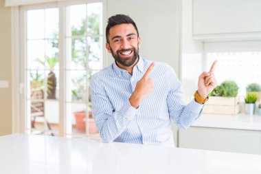 Yakışıklı İspanyol iş adamı gülümseyen ve iki el ve parmak tarafına işaret kamera bakıyor.