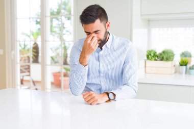 Yakışıklı İspanyol iş adamı yorgun sürtünme burun ve gözleri yorgunluk ve baş ağrısı hissi. Stres ve hayal kırıklığı kavramı.