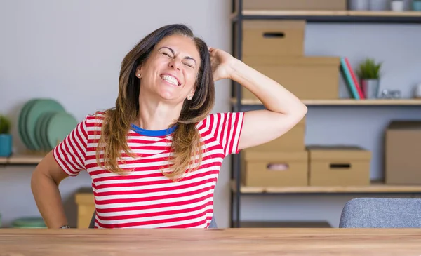 Mujer Mayor Mediana Edad Sentada Mesa Casa Estirándose Hacia Atrás — Foto de Stock