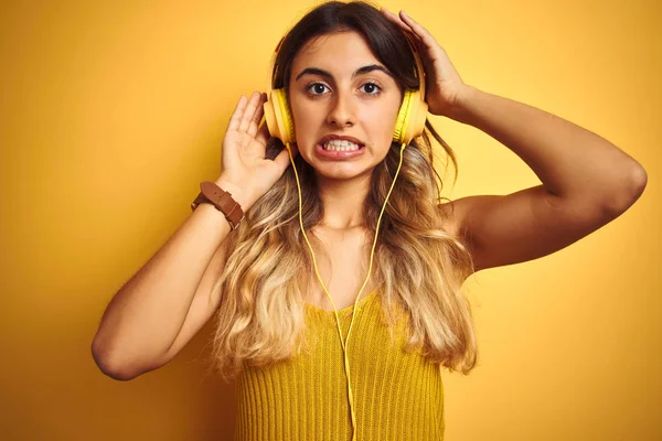 Young Beautiful Woman Wearing Headphones Yellow Isolated Background Stressed Hand — Stock Photo, Image