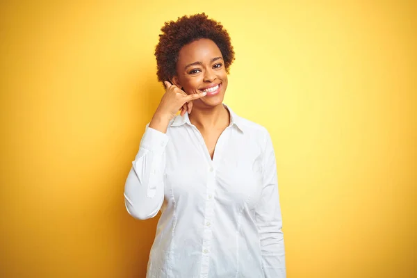 孤立した黄色の背景の上にアフリカ系アメリカ人のビジネス女性は 電話で話すような手や指で携帯電話のジェスチャーを行う笑顔 概念の伝達 — ストック写真