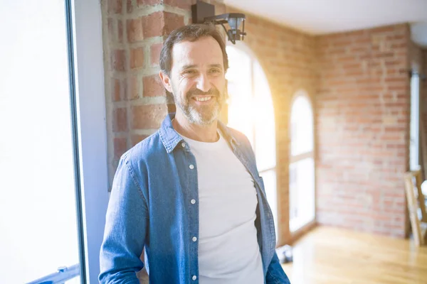 Homem de meia idade sênior sorrindo feliz movendo-se para outra casa, hap — Fotografia de Stock