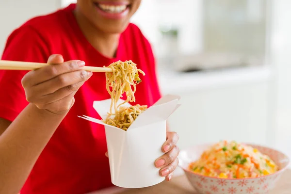 箸を使って宅配ボックスから麺を食べる若い女性のクローズアップ — ストック写真